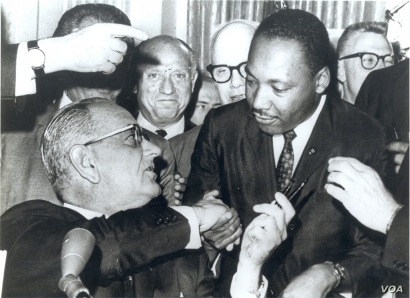  Photograph of President Lyndon Johnson signing the Voting Rights Act as Martin Luther King, Jr., with other civil rights leaders in the Capitol Rotunda, Washington, DC, August 6, 1965. Creative Commons